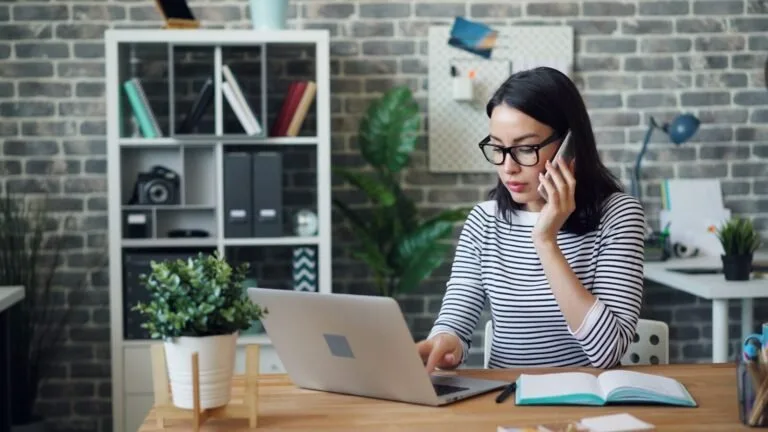A woman sitting at a desk using a laptop computer