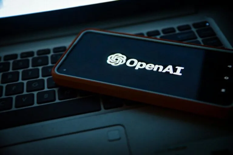 A cell phone sitting on top of a laptop computer