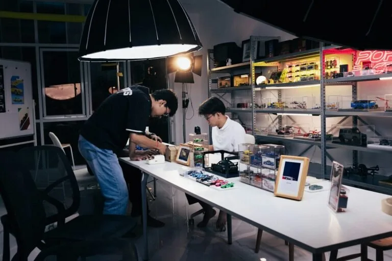 Two people working at a table in a studio.
