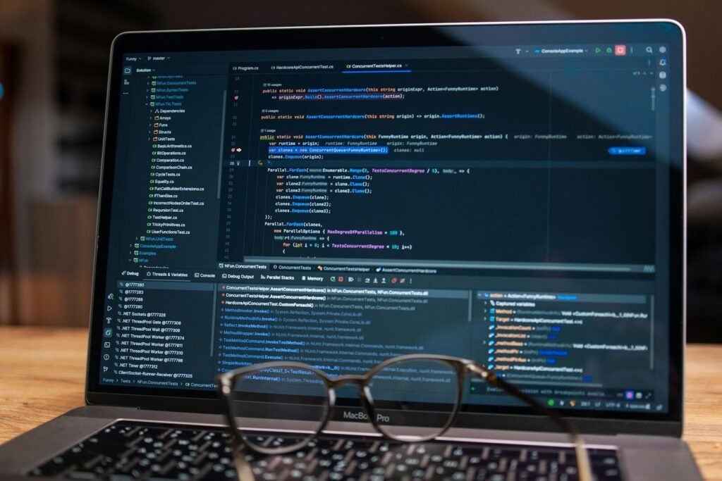 Laptop Screen Displaying Lines Of Code With Glasses.